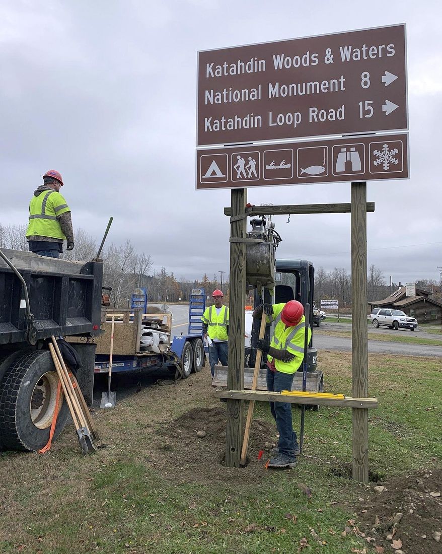 In this photo provided by Friends of Katahdin Woods and Water, contractors install a sign directing motorists to the Katahdin Woods and Waters National Monument on Wednesday, Oct. 30, 2019, in Sherman, Maine. The sign is one of 22 that will be installed before month's end on state roads and on Interstate 95. (Kala Rush/Friends of Katahdin Woods and Water via AP)