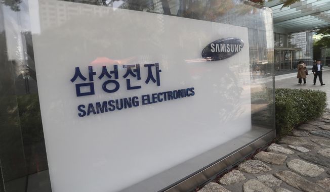 People walk near the logo of the Samsung Electronics Co. at its office in Seoul, South Korea, Thursday, Oct. 31, 2019. (AP Photo/Ahn Young-joon) ** FILE **