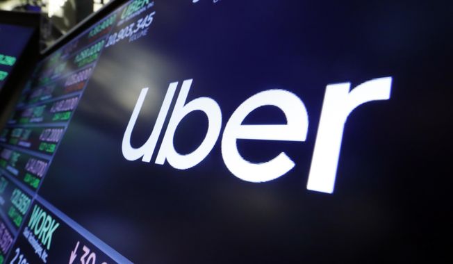 In this Aug. 16, 2019, file photo, the logo for Uber appears above a trading post on the floor of the New York Stock Exchange. (AP Photo/Richard Drew, File)