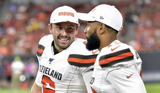 FILE - In this Aug. 8, 2019, file photo, Cleveland Browns&#39; Baker Mayfield, left, smiles as he talks with wide receiver Odell Beckham Jr. during the second half of an NFL preseason football game against the Washington Redskins in Cleveland. Beckham believes the Browns offense will come around. Until then, he’s going to defend Mayfield. (AP Photo/David Richard, File)