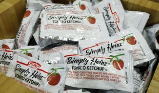 In this Aug. 8, 2019, file photo packets of Simply Heinz ketchup fill a cafeteria condiment box in New York. (AP Photo/Richard Drew, File)  **FILE**