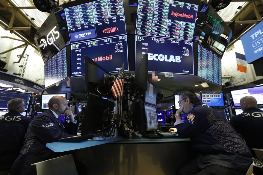 FILE - In this Oct. 21, 2019, file photo specialists James Denaro, left center, and Gregg Maloney, right center, work on the floor of the New York Stock Exchange. President Donald Trump said Thursday, Oct. 31, that the impeachment inquiry is hurting the stock market. While it’s tough to tease out its impact for certain given all the given all the moving parts that go into setting stock prices, many investors on Wall Street see it having only a modest effect, and one unlikely to last for long. (AP Photo/Richard Drew, File)