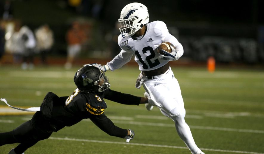 Georgia Southern running back Wesley Kennedy III (12) gets pressure from Appalachian State defensive back Shaun Jolly (3) during the first half of an NCAA college football game Thursday, Oct. 31, 2019, in Boone, N.C. (AP Photo/Brian Blanco)