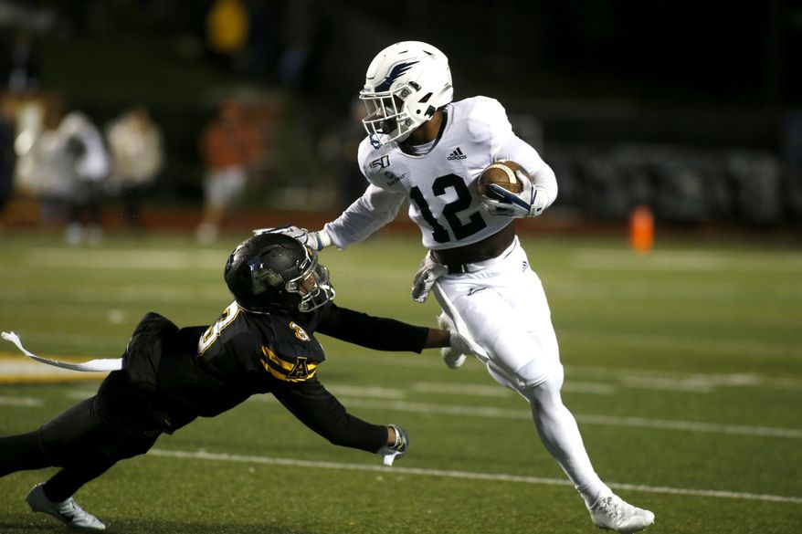 Georgia Southern running back Wesley Kennedy III (12) gets pressure from Appalachian State defensive back Shaun Jolly (3) during the first half of an NCAA college football game Thursday, Oct. 31, 2019, in Boone, N.C. (AP Photo/Brian Blanco)