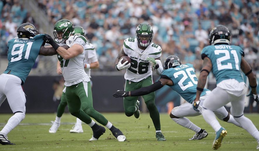 FILE - In this Oct. 27, 2019, file photo, New York Jets running back Le'Veon Bell (26) rushes for yardage in front of Jacksonville Jaguars defensive back Jarrod Wilson (26), defensive end Yannick Ngakoue (91) and cornerback A.J. Bouye (21) during the first half of an NFL football game in Jacksonville, Fla. Bell didn't like how little he was used in the 29-15 loss at Jacksonville, and Bell needed to make sure Jets coach Adam Gase knew what he was feeling. “I was a little frustrated,” Bell said Thursday. “I'm always frustrated at a loss, but this was a little different because I wasn't involved and we lost.” Bell carried the ball eight times for 23 yards and had three catches for 12 yards. (AP Photo/Phelan M. Ebenhack, File)