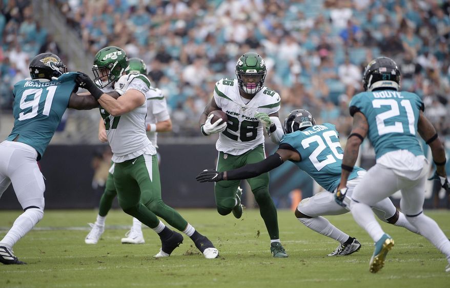 FILE - In this Oct. 27, 2019, file photo, New York Jets running back Le'Veon Bell (26) rushes for yardage in front of Jacksonville Jaguars defensive back Jarrod Wilson (26), defensive end Yannick Ngakoue (91) and cornerback A.J. Bouye (21) during the first half of an NFL football game in Jacksonville, Fla. Bell didn't like how little he was used in the 29-15 loss at Jacksonville, and Bell needed to make sure Jets coach Adam Gase knew what he was feeling. “I was a little frustrated,” Bell said Thursday. “I'm always frustrated at a loss, but this was a little different because I wasn't involved and we lost.” Bell carried the ball eight times for 23 yards and had three catches for 12 yards. (AP Photo/Phelan M. Ebenhack, File)
