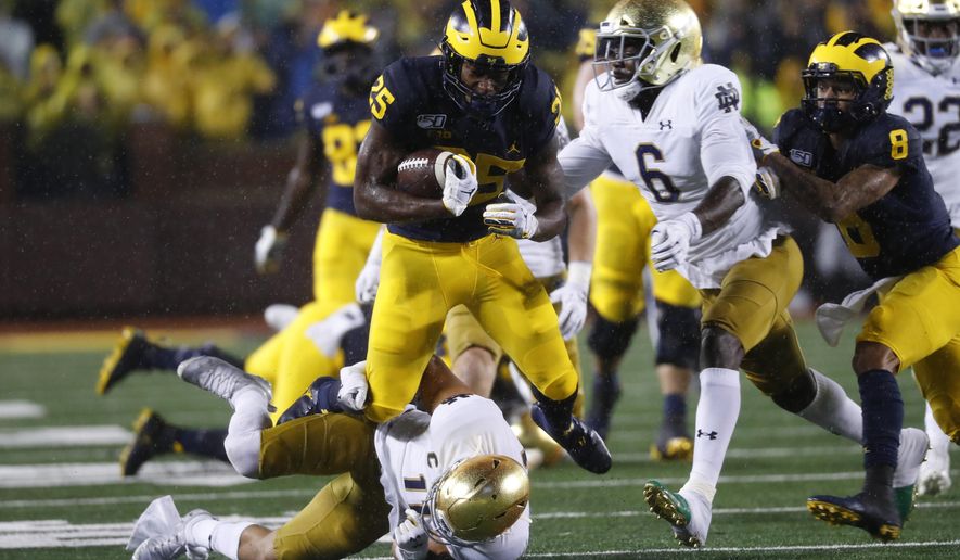 Michigan running back Hassan Haskins (25) runs over Notre Dame safety Alohi Gilman (11) during a 20-yard gain in the first half of an NCAA college football game in Ann Arbor, Mich., Saturday, Oct. 26, 2019. (AP Photo/Paul Sancya)