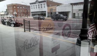FILE - In this July 16, 2018, file photo Main Street is reflected in a display window of a store in Scribner, Neb. In 2019, investors have relied on bricks and mortar to balance the riskier parts of their portfolios and get a good return. The S&amp;amp;P 500’s real estate sector has been outpacing the broader market throughout the year. It’s the second best performing index in the index, in between technology and communications companies. (AP Photo/Nati Harnik, File)