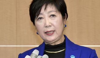 FILE - In this Wednesday, Oct. 30, 2019, file photo, Tokyo Gov. Yuriko Koike speaks to reporters after a meeting with International Olympic Committee officials in Tokyo. The International Olympic Committee abruptly announced two weeks ago it was moving next year’s Olympic marathon from Tokyo to the northern city of Sapporo. The change has infuriated Koike and created a public fight between the powerful, Switzerland-based IOC, and Tokyo which is spending about $25 billion to organize the Olympics - 80% public money. (Kyodo News via AP, File)