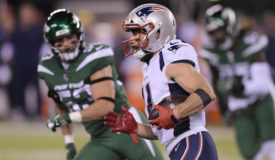 New England Patriots wide receiver Julian Edelman, right, runs past New York Jets linebacker Blake Cashman during the first half of an NFL football game Monday, Oct. 21, 2019, in East Rutherford, N.J. (AP Photo/Bill Kostroun)