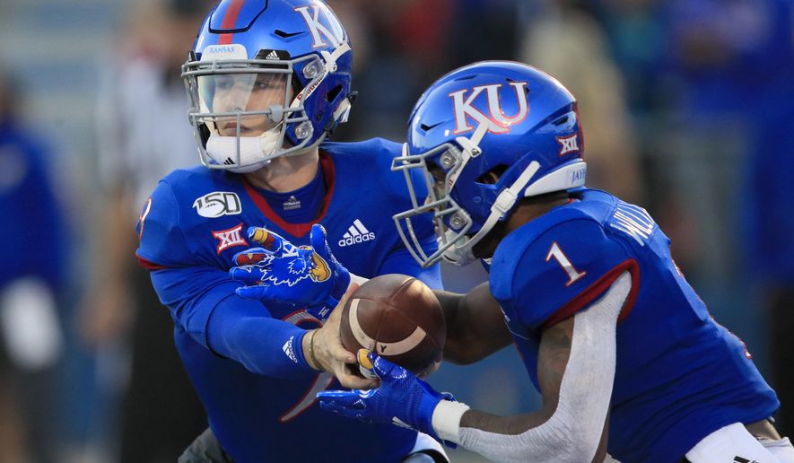 Kansas quarterback Carter Stanley, left, hands off to running back Pooka Williams Jr. (1) during the first half of an NCAA college football game against Texas Tech in Lawrence, Kan., Saturday, Oct. 26, 2019. (AP Photo/Orlin Wagner)