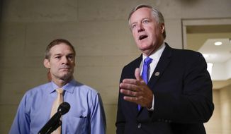 In this file photo, Rep. Mark Meadows, R-N.C., right, speaks to members of the media as Rep. Jim Jordan, R-Ohio, left, looks on as they arrive for closed-door meeting to hear testimony from Tim Morrison, a former senior National Security Council official, in the House impeachment inquiry about President Donald Trump&#39;s efforts to press Ukraine to investigate his political rivals, at the Capitol in Washington, Thursday, Oct. 31, 2019. (AP Photo/Pablo Martinez Monsivais) ** FILE **