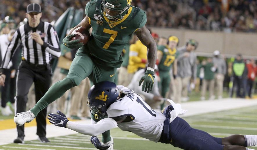 Baylor running back John Lovett (7) is tackled by West Virginia safety Kerry Martin Jr. (15) during the first half of an NCAA college football game in Waco, Texas, Thursday, Oct. 31, 2019. (AP Photo/Jerry Larson)
