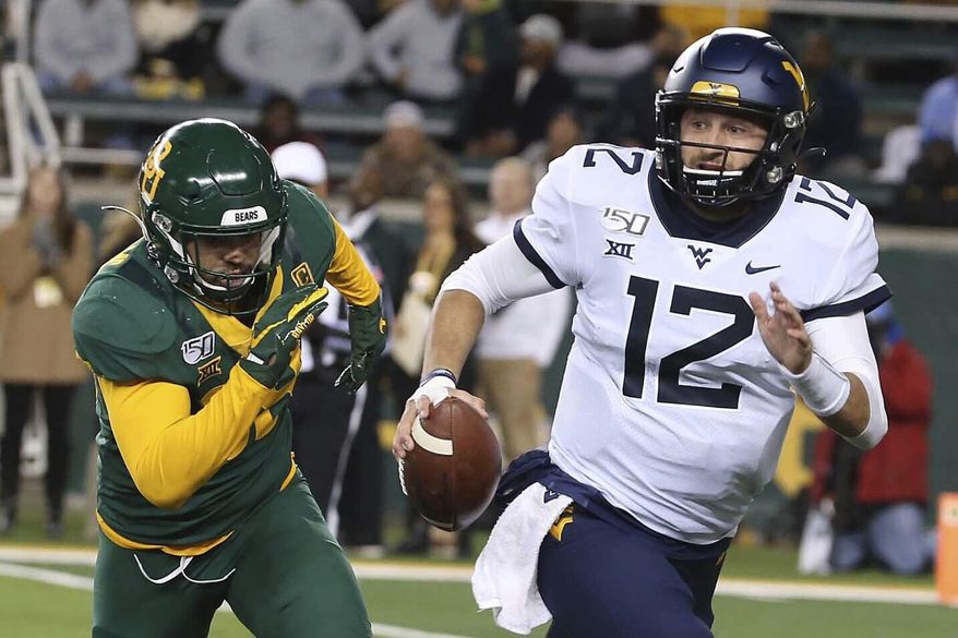 West Virginia quarterback Austin Kendall (12) runs from Baylor linebacker Jordan Williams (38) during the first half of an NCAA college football game in Waco, Texas, Thursday, Oct. 31, 2019. (AP Photo/Jerry Larson)