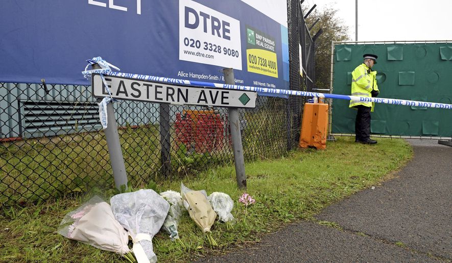 Floral tributes at the Waterglade Industrial Park in Thurrock, Essex, England Thursday Oct. 24, 2019 the day after 39 bodies were found inside a truck on the industrial estate. British media are reporting that the 39 people found dead in the back of a truck in southeastern England were Chinese citizens. (Stefan Rousseau, PA via AP)