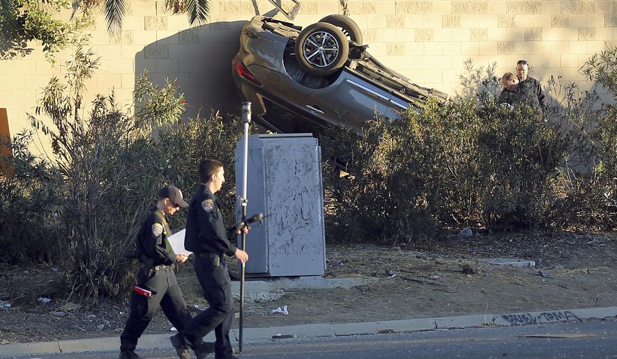 California Highway Patrol investigators view the scene of a pursuit that ended in a crash on the Hollywood Freeway near downtown Los Angeles Friday, Nov. 1, 2019. Three people in the car died at the scene; a fourth was in a hospital in critical condition. (AP Photo/Reed Saxon)
