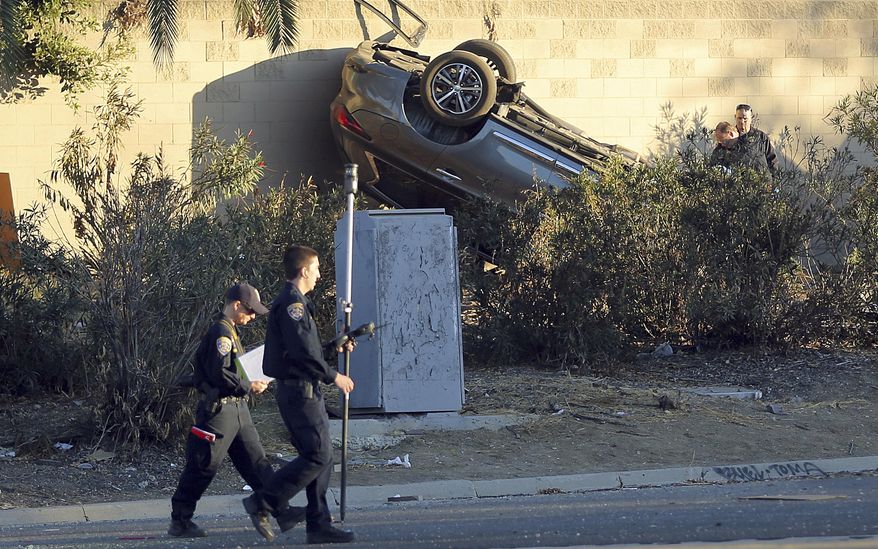 California Highway Patrol investigators view the scene of a pursuit that ended in a crash on the Hollywood Freeway near downtown Los Angeles Friday, Nov. 1, 2019. Three people in the car died at the scene; a fourth was in a hospital in critical condition. (AP Photo/Reed Saxon)