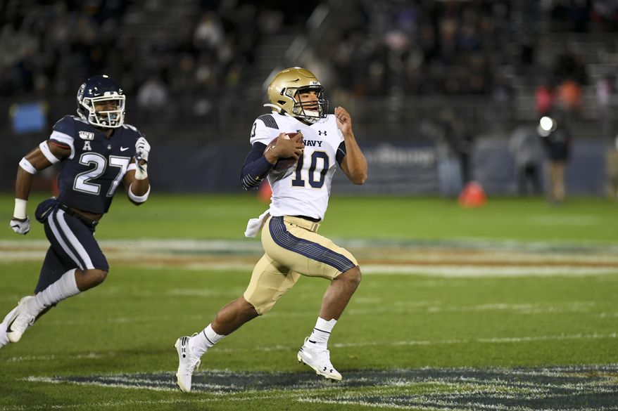 Navy quarterback Malcolm Perry (10) takes the ball in for Navy's first touchdown during the first half of an NCAA college football game against Connecticut on Friday, Nov. 1, 2019, in East Hartford, Conn. (AP Photo/Stephen Dunn)
