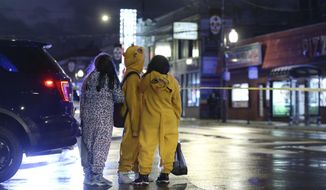 A group of children view a crime scene, where a seven-year-old girl was shot while trick-or-treating Thursday, Oct. 31, 2019, in Chicago. The girl, who was shot in the upper chest area, was taken to Stroger Hospital in critical condition, according to Fire Department spokesman Larry Langford. (John J. Kim/Chicago Tribune via AP)