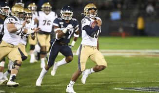 Navy quarterback Malcolm Perry (10) takes the ball in for Navy&#39;s first touchdown during the first half of an NCAA college football game against Connecticut on Friday, Nov. 1, 2019, in East Hartford, Conn. (AP Photo/Stephen Dunn) ** FILE **