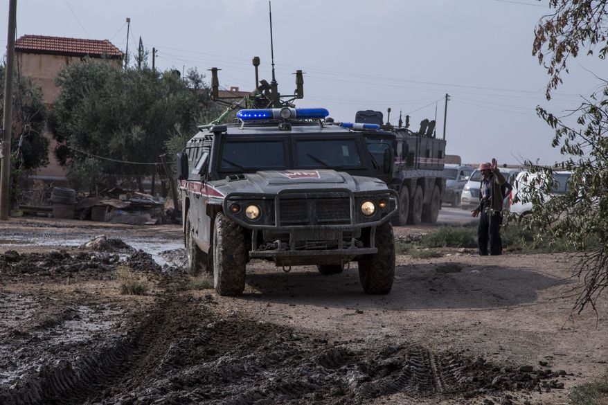 Turkish and Russian patrol is seen near the town of Darbasiyah, Syria, Friday, Nov. 1, 2019. Turkey and Russia launched joint patrols Friday in northeastern Syria, under a deal that halted a Turkish offensive against Syrian Kurdish fighters who were forced to withdraw from the border area following Ankara's incursion.(AP Photo/Baderkhan Ahmad)