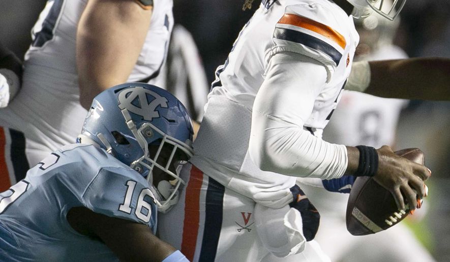 Virginia quarterback Bryce Perkins (3) is sacked by North Carolina's D.J. Ford on third down for a 7-yard loss during the second quarter of an NCAA college football game Saturday, Nov. 2, 2019, in Chapel Hill, N.C. (Robert Willett/The News & Observer via AP)
