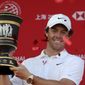 Rory McIlroy of Northern Ireland raises the trophy after winning the HSBC Champions golf tournament at the Sheshan International Golf Club in Shanghai on Sunday, Nov. 3, 2019. (AP Photo/Ng Han Guan)