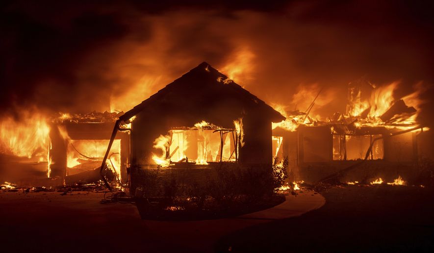 FILE - In this Oct. 31, 2019 file photo flames from the Hillside Fire consume a home in San Bernardino, Calif. President Donald Trump on Sunday, Nov. 3 threatened to cut U.S. funding to California for aid during wildfires that have burned across the state during dry winds this fall. (AP Photo/Noah Berger,File)