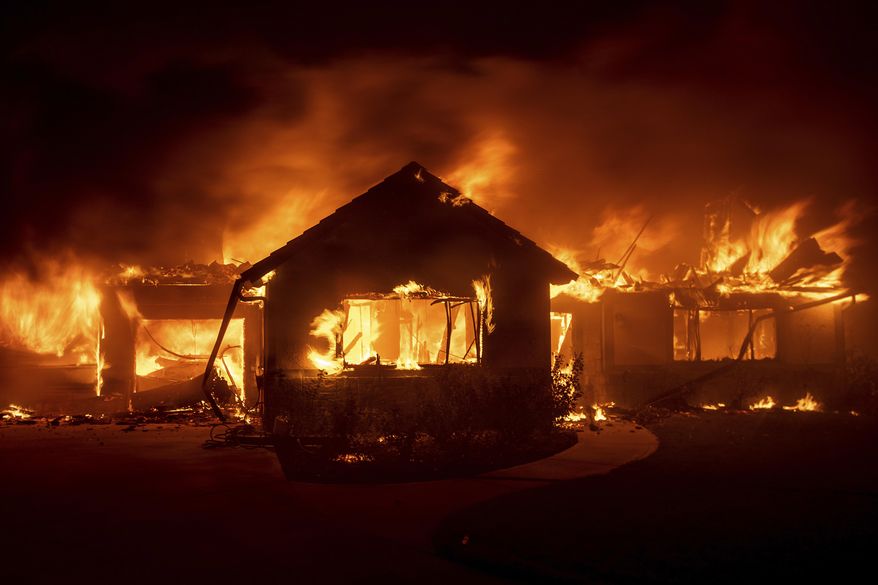 FILE - In this Oct. 31, 2019 file photo flames from the Hillside Fire consume a home in San Bernardino, Calif. President Donald Trump on Sunday, Nov. 3 threatened to cut U.S. funding to California for aid during wildfires that have burned across the state during dry winds this fall. (AP Photo/Noah Berger,File)