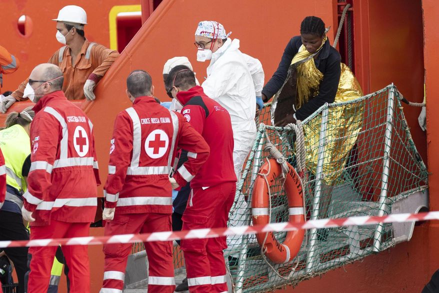 A woman disembarks from the Asso Trenta ship, docked in the port of Pozzallo, Italy, Sunday, Nov. 3, 2019. An Italian offshore supply vessel has brought 151 migrants to Sicily after rescuing them in waters off Libya a day earlier. (Francesco Ruta/ANSA via AP)