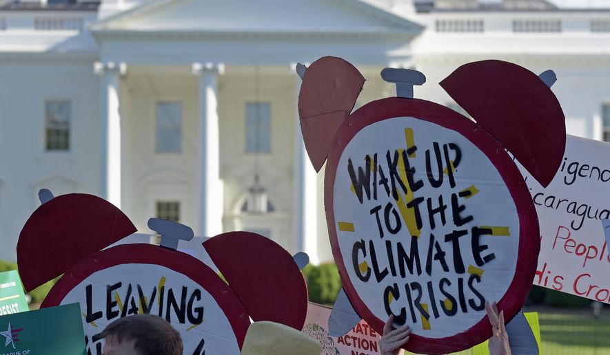 In this June 1, 2017, file photo, protesters gather outside the White House in Washington to protest President Donald Trump&#39;s decision to withdraw the United States from the Paris climate change accord. (AP Photo/Susan Walsh)