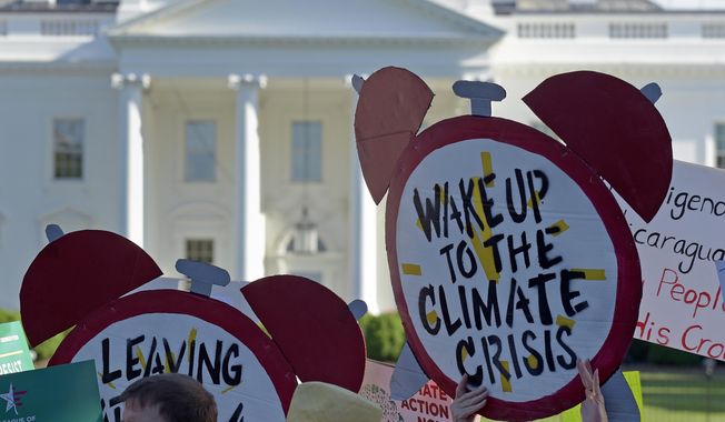 In this June 1, 2017, file photo, protesters gather outside the White House in Washington to protest President Donald Trump&#x27;s decision to withdraw the United States from the Paris climate change accord. (AP Photo/Susan Walsh)