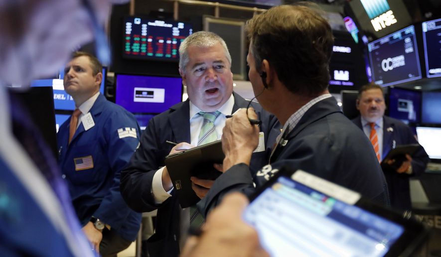 FILE - In this Oct. 29, 2019, file photo Edward McCarthy, center, works with fellow traders on the floor of the New York Stock Exchange. The U.S. stock market opens at 9:30 a.m. EST on Monday, Nov 4. (AP Photo/Richard Drew, File)