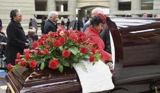Monica Conyers, widow of the late U.S. Rep. John Conyers, pauses at her husband&#39;s casket during visitation services at the Charles H. Wright Museum of African American History in Detroit on Sunday, Nov. 3, 2019. Conyers died Sunday, Oct. 27, at age 90, two years after resigning from the U.S. House. (Robin Buckson/Detroit News via AP)