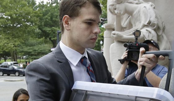 FILE - In this Aug. 13, 2019 file photo, Nathan Carman carries documents as he arrives at federal court in Providence, R.I., where he faced civil charges over insurance issues regarding the boat aboard which he and his mother went out to sea for a night of fishing in 2016. U.S. District Judge John McConnell ruled Monday, Nov. 4, in favor on an insurance company that refused to pay an $85,000 claim to Carman for the loss of his boat, The Chicken Pox. (AP Photo/Steven Senne, File)