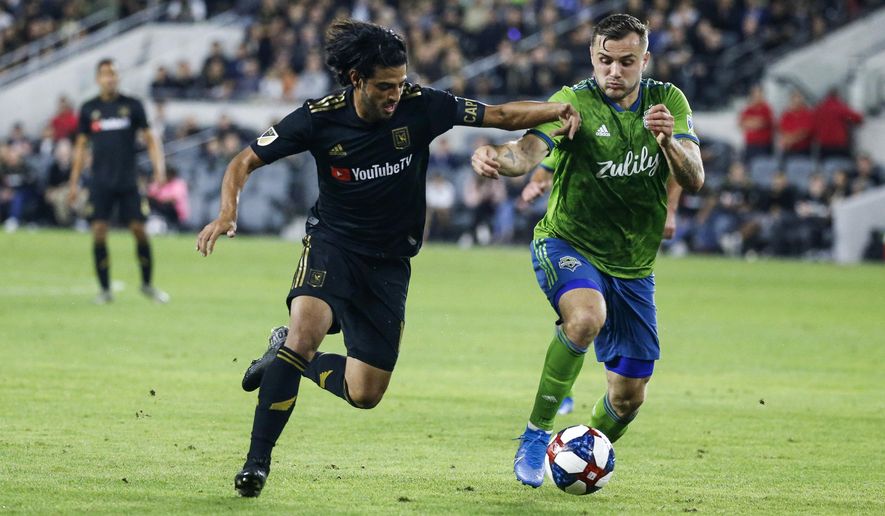 Los Angeles FC forward Carlos Vela, left, vies against Seattle Sounders forward Jordan Morris during the second half of the MLS soccer Western Conference final Tuesday, Oct. 29, 2019, in Los Angeles. The Sounders won 3-1. (AP Photo/Ringo H.W. Chiu)