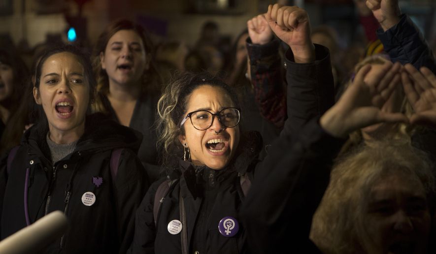 Women shout outside the Justice Ministry in Madrid, Spain, Monday, Nov. 4, 2019. Thousands in Spain are demonstrating to demand changes in criminal laws and the country's judiciary after a new ruling on a sex assault case revived the debate over the fair treatment of victims. Monday's protests come after five men accused of gang raping an unconscious 14-year-old three years ago were sentenced between 10 to 12 years behind bars for sexual abuse instead of assault or rape.(AP Photo/Paul White)