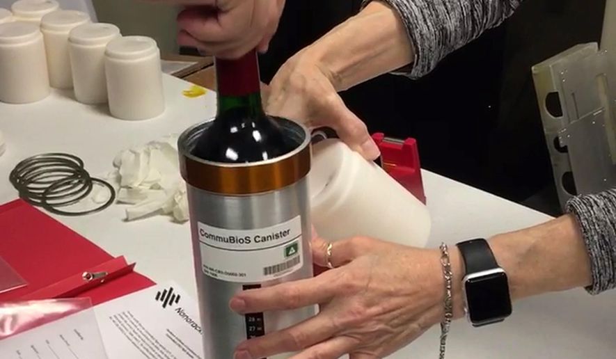 In this Saturday, Nov. 2, 2019 photo provided by Space Cargo Unlimited, researchers with Space Cargo Unlimited prepare bottles of French red wine to be flown aboard a Northrop Grumman capsule from Wallops Island, Va., to the International Space Station. The wine will age for a year up there before returning to the Luxembourg company. Company officials say researchers will study how weightlessness and space radiation affect the aging process. (Space Cargo Unlimited via AP)