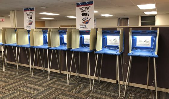 In this Sept. 20, 2018 photo, voting booths stand ready in downtown Minneapolis for the opening of early voting in Minnesota. A majority of Americans are concerned that a foreign government might interfere in some way in the 2020 presidential election, whether by tampering with election results, stealing information or by influencing candidates or voter opinion, a new poll shows.(AP Photo/Steve Karnowski)