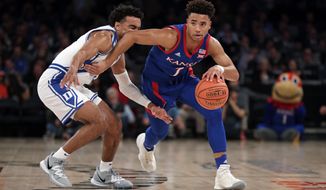 Kansas guard Devon Dotson (1) drives to the basket past Duke guard Tre Jones during the first half of an NCAA college basketball game Tuesday, Nov. 5, 2019, in New York. (AP Photo/Adam Hunger)