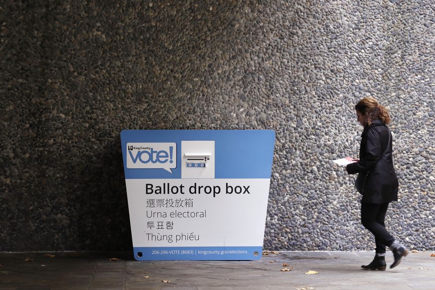 A voter heads to a ballot drop box Monday, Nov. 4, 2019, in Seattle. Voters in Washington state have a crowded ballot to fill out for this week&#39;s election, with a referendum on affirmative action and an initiative on the price of car tabs among the things they are being asked to decide. (AP Photo/Elaine Thompson)