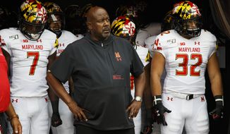 In this Sept. 14, 2019, file photo, Maryland head coach Michael Locksley, center, looks on as he is about to lead his team out of the tunnel for the first half of an NCAA college football against Temple, in Philadelphia. One year ago, Maryland took Ohio State into overtime before a failed 2-point conversion resulted in a 52-51 defeat. In the rematch Saturday, the Terrapins are a 43-point underdog. (AP Photo/Chris Szagola) ** FILE **