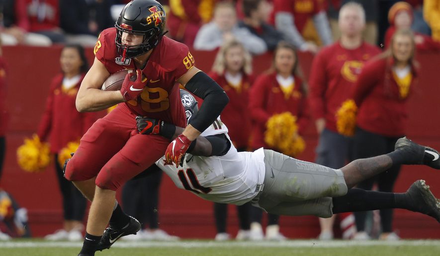 Iowa State tight end Charlie Kolar, left, runs the ball as Oklahoma State linebacker Amen Ogbongbemiga, right, leaps to make the tackle during the second half of an NCAA college football game, Saturday, Oct. 26, 2019, in Ames, Iowa. Oklahoma State won 34-27. (AP Photo/Matthew Putney)
