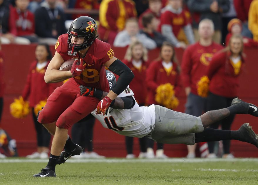 Iowa State tight end Charlie Kolar, left, runs the ball as Oklahoma State linebacker Amen Ogbongbemiga, right, leaps to make the tackle during the second half of an NCAA college football game, Saturday, Oct. 26, 2019, in Ames, Iowa. Oklahoma State won 34-27. (AP Photo/Matthew Putney)
