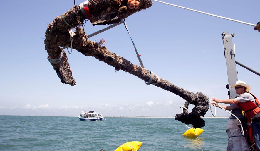 FILE- In this May 27, 2011 file photo, a 3,000 pound anchor from what is believed to be the wreck of the pirate Blackbeard's flagship, the Queen Anne's Revenge, is recovered from the ocean where it has been since 1718, in Beaufort Inlet, in Carteret County N.C. The Supreme Court is wrestling with a modern-day dispute involving the pirate Blackbeard's ship that went down off North Carolina’s coast more than 300 years ago. The justices on Tuesday heard arguments in a copyright case over photos and videos that document the recovery of the Queen Anne’s Revenge, discovered in 1996. (Robert Willett/The News & Observer via AP)