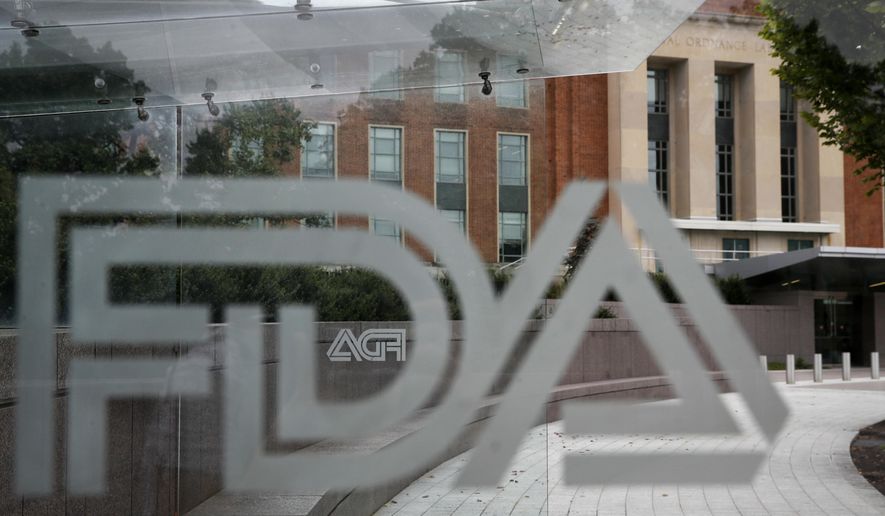 This Aug. 2, 2018, file photo shows the U.S. Food and Drug Administration building behind FDA logos at a bus stop on the agency&#39;s campus in Silver Spring, Md.  (AP Photo/Jacquelyn Martin, File) **FILE**