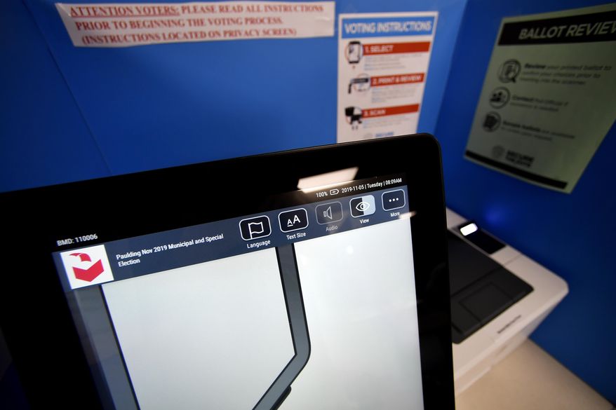 A touchscreen voting machine and printer are seen in a voting booth, in this file photo from Tuesday, Nov. 5, 2019, in Paulding, Ga. (AP Photo/Mike Stewart) **FILE**