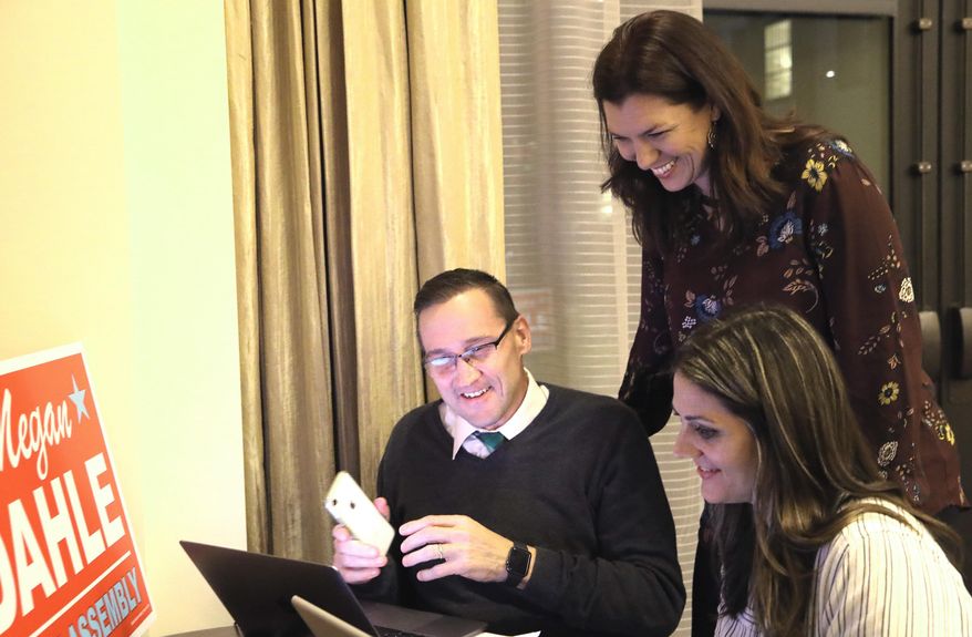 Republican Megan Dahle, standing, checks results with campaign volunteers Josh Cook, left, and Tenessa Audette, right, at her election night party in Redding, Calif., Tuesday, Nov. 5, 2019. Dahle faced Democrat Elizabeth Betancourt for an Assembly seat in District 1. (Michael Chapman/The Record Searchlight via AP)