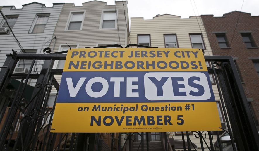 A sign urging people to vote on municipal question #1 is displayed in Jersey City, N.J., Tuesday, Nov. 5, 2019. Residents of New Jersey's second-largest city will decide Tuesday whether its increasing popularity as an affordable short-term rental option across the river from New York City has reached the point where restrictions are needed to rein in some of the unwanted byproducts.(AP Photo/Seth Wenig)