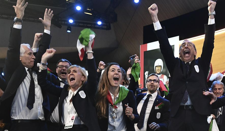 FILE - In this Monday, June 24, 2019 file photo, members of the Milan-Cortina delegation celebrate after winning the bid to host the 2026 Winter Olympic Games, during the first day of the 134th Session of the International Olympic Committee (IOC), at the SwissTech Convention Centre, in Lausanne, Switzerland. Former telecommunications chief Vincenzo Novari has been named the CEO of the organizing committee for the Milan-Cortina 2026 Winter Olympics. (Philippe Lopez/Pool via AP, File)